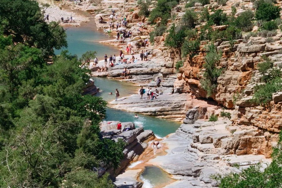 a group of people standing on top of a taghazout beach with boards