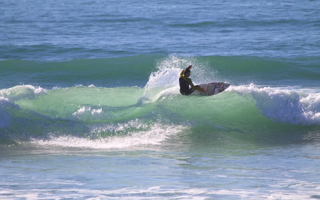 a group of people standing on top of a taghazout beach with boards